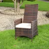 A single brown rattan garden chair with a beige cushion sits on a green lawn. Produktbild-Vorschau