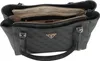 A black Guess shopper bag with a repeating logo pattern is shown from a top-down perspective, with the main compartment open to reveal the interior. Produktbild-Vorschau