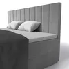A close-up view of a grey upholstered box spring bed with two white pillows and a dark grey blanket. Náhled obrázku produktu