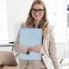 A woman in a business suit holds a light blue laptop bag in an office setting. Produktbild-Vorschau