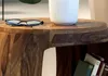 A close-up of a wooden side table with glasses and a vase on top, and books on the shelf below. Podgląd zdjęcia produktu
