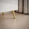 Close-up of the legs of a white cabinet on a wooden floor. Produktbild-Vorschau