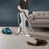 A person vacuuming a spill on the floor. Voir les images du produit