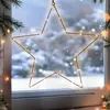 A star-shaped light decoration hangs in a window on a snowy day. Anteprima dell’immagine prodotto