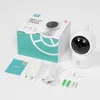A white Sinji pan & tilt indoor camera and its accessories are laid out on a white surface, next to its packaging. Produktbild-Vorschau