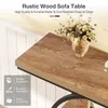 Close-up of a rustic wood sofa table with a vase of flowers on top. Voir les images du produit