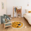 A child's bedroom with a bed, a clothing rack, a rug, and a chair. Náhled obrázku produktu
