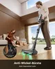 A man is using a cordless vacuum cleaner in a modern living room, while a woman pets their dog on the couch. Produktbild-Vorschau