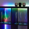 Champagne flutes are displayed on shelves with colorful LED lighting. Produktbild-Vorschau