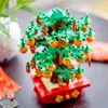 A close-up shot of a LEGO model of a lucky chestnut tree, decorated with miniature red envelopes and gold coins, placed in a red pot. Produktbild-Vorschau