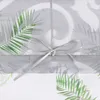 A close-up of a sheer curtain with a palm leaf pattern and a ribbon tie. Produktbild-Vorschau