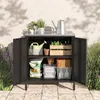 An outdoor storage cabinet filled with gardening supplies, placed on a patio. Produktbild-Vorschau