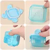 A collage of four images showing a small, square, light blue plastic food container with a white silicone seal and a blue lid. The images demonstrate how to open, close, and use the container. Produktbild-Vorschau