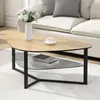 A modern coffee table with a kidney-shaped wooden top and a black metal frame, placed on a white rug in a living room setting. Voir les images du produit