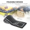 A flexible keyboard is shown rolled up, with a blurred background of luggage and a hat, suggesting travel. Voir les images du produit