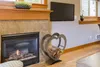 A living room scene with a fireplace and a heart-shaped log holder. Produktbild-Vorschau