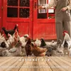 A person is feeding chickens in front of a red coop. Produktbild-Vorschau