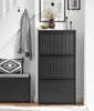 An entryway scene featuring a black shoe cabinet, a bench with a cushion and pillow, and a coat hanging on hooks. Produktbild-Vorschau