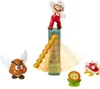 A collection of Super Mario figures, including Mario, Goomba, Fire Flower, and a Koopa Troopa, arranged in a diorama-like setting with a lava castle element. Produktbild-Vorschau