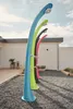 Four colorful outdoor showers are lined up in a gravel area next to a building. Produktbild-Vorschau