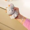 A hand is squeezing a gray cat-shaped stress toy. Voir les images du produit