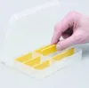 A hand is shown placing a yellow divider into a transparent storage box with multiple compartments. Voir les images du produit
