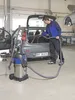 A man is vacuuming the interior of a car in a garage or workshop. Anteprima dell’immagine prodotto