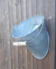 A galvanized metal bucket with a wooden handle is attached to a wooden fence. Produktbild-Vorschau