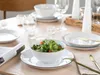 A table setting with plates, bowls, cutlery, and glasses, featuring a salad in a bowl. Náhľad obrázku produktu