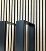 Two black metal table legs are shown in front of a slatted wood and black background. Náhľad obrázku produktu