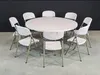 A round table with chairs around it, set against a dark background. Produktbild-Vorschau