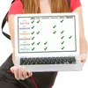 A person holds up a laptop displaying a comparison chart of different Neo Cap Bacter products and their features. Produktbild-Vorschau