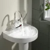 A close-up shot of a bathroom sink with a faucet dispensing hot water, creating steam. Produktbild-Vorschau