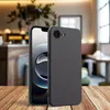 A smartphone case is shown on a wooden table in a cafe setting. Produktbild-Vorschau