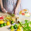 A person is preparing fruit for infused water in a kitchen setting. Produktbild-Vorschau