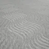 A close-up view of a light gray mattress cover with a wavy pattern. Produktbild-Vorschau