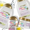 A collection of Ogx Coconut Miracle Oil hair products with water splashes. Produktbild-Vorschau