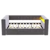 A gray upholstered sofa bed with a wooden slat base is shown from the front against a white background. The headboard has button tufting, and there is a yellow illuminated shelf on the right side. Náhľad obrázku produktu