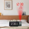 A digital alarm clock projecting the time and temperature onto a wall above a bed. Podgląd zdjęcia produktu