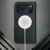 A black leather iPhone case with a MagSafe charger attached, laid flat on a gray surface. Anteprima dell’immagine prodotto