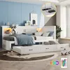 A white daybed with a pull-out trundle bed, decorated with pillows and blankets, in a child's bedroom. The image highlights LED lighting and a charging station. Produktbild-Vorschau