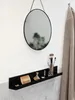 A shelf with various bathroom or vanity items, including makeup brushes, a perfume bottle, and a comb, mounted on a wall. Produktbild-Vorschau