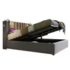 A grey upholstered bed with its storage compartment open, revealing the mattress and frame. Produktbild-Vorschau