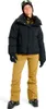 A woman wearing ski gear, including a black puffer jacket, tan ski pants, black gloves, and goggles, stands against a white background. Náhľad obrázku produktu