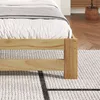 Close-up of a wooden bed frame with bedding on a rug. Anteprima dell’immagine prodotto