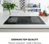 A modern kitchen counter with an induction cooktop, vegetables, and a plant in the background. Náhľad obrázku produktu