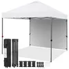 A white pop-up canopy tent is set up, with its frame and a side wall visible. Accessories like a carrying bag, folded frame, weights, and stakes are laid out in front of it. Produktbild-Vorschau