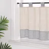 A close-up view of a kitchen curtain hanging on a rod in front of a window. Produktbild-Vorschau