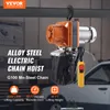 An electric chain hoist is shown hanging from a beam in what appears to be a workshop or garage setting. The background shows a car and some equipment. Anteprima dell’immagine prodotto