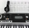 A close-up view of a digital keyboard with headphones resting on a stand above it. Produktbild-Vorschau